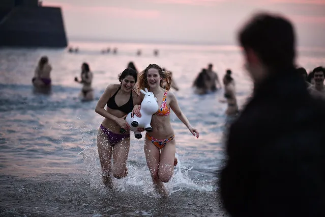Students from St Andrews University take part in the traditional May Day dip into the North Sea at East Sands beach on May 1, 2019 in St Andrews, Scotland.The university says the May Day Dip is believed to promote good luck in exams. (Photo by Jeff J. Mitchell/Getty Images)