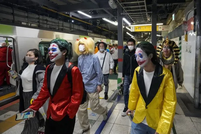 Halloween goers arrive in costumes at a train station as thousands continue gathering in Shibuya district, a popular gathering area for Halloween after midnight on Monday, November 1, 2021, in Tokyo. (Photo by Kiichiro Sato/AP Photo)