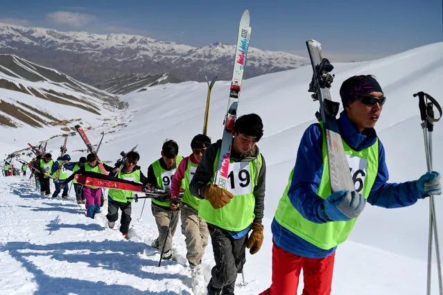 Afghan skiers walk uphill to compete in a ski race on the outskirts of Bamiyan province on March 8, 2024. (Photo by Wakil Kohsar/AFP Photo)