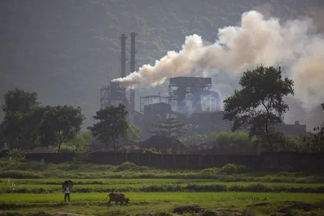 Smoke rises from a coal-powered steel plant at Hehal village near Ranchi, in eastern state of Jharkhand, Sunday, September 26, 2021. No country will see energy needs grow faster in coming decades than India, and even under the most optimistic projections part of that demand will have to be met with dirty coal power – a key source of heat-trapping carbon emissions. (Photo by Altaf Qadri/AP Photo)