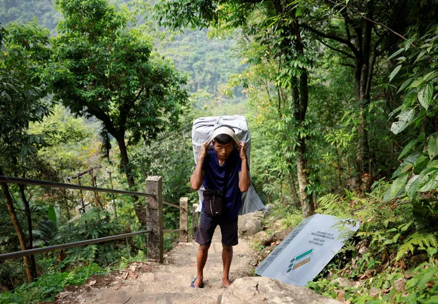 Wilfred Syjemlieh, 24, a porter, carries Voter Verifiable Paper Audit Trail (VVPAT) and Electronic Voting Machines (EVM) as he treks to reach a remote polling station, ahead of the first phase of the election, in Shillong in the northeastern state of Meghalaya, India, on April 17, 2024. (Photo by Adnan Abidi/Reuters)