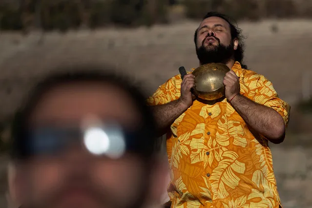 A man prays during the solar eclipse, from Puclaro, Coquimbo Region, Chile, on July 02, 2019. Tens of thousands of tourists braced Tuesday for a rare total solar eclipse that was expected to turn day into night along a large swath of Latin America's southern cone, including much of Chile and Argentina. (Photo by Claudio Reyes/AFP Photo)