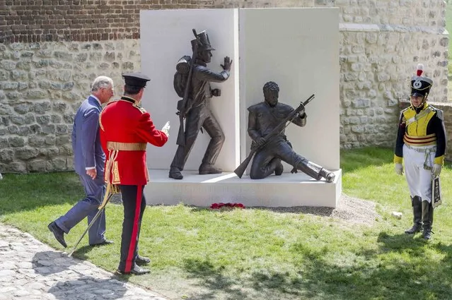 Britain's Prince Charles (L) walks by a newly-unveiled monument during a ceremony for the opening of the Hougoumont farm as part of the bicentennial celebrations for the Battle of Waterloo, near Waterloo, Belgium June 17, 2015. The commemorations for the 200th anniversary of the Battle of Waterloo will take place in Belgium on June 19 and 20. REUTERS/Geert Vanden Wijngaert/Pool