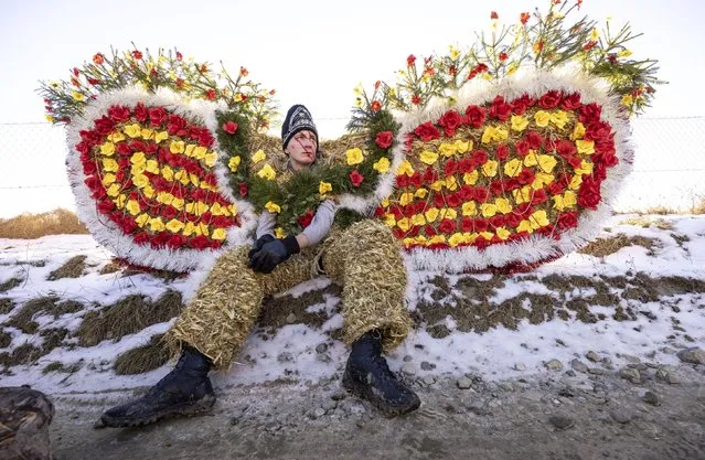 A villager, dressed in a traditional bear costume, celebrates the Malanka festival in the village of Krasnoilsk, Ukraine, Friday, January 14, 2022. Dressed as goats, bears, oxen and cranes, many Ukrainians rang in the new year last week in the colorful rituals of the Malanka holiday. Malanka, which draws on pagan folk tales, marks the new year according to the Julian calendar, meaning it falls on Jan. 13-14. In the festivities, celebrants go from house to house, where the dwellers offer them food. (Photo by Ethan Swope/AP Photo)