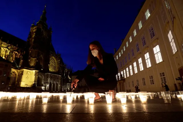A woman lights a candle to commemorate all Czech victims of the coronavirus disease (COVID-19) pandemic at Prague Castle in Prague, Czech Republic, May 10, 2021. (Photo by David W. Cerny/Reuters)