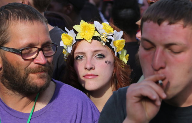 Partygoers listen to live music and smoke pot on the second of two days at the annual 4/20 marijuana festival in Denver, Sunday April 20, 2014. The annual event is the first 420 marijuana celebration since retail marijuana stores began selling in January 2014. (Photo by Brennan Linsley/AP Photo)