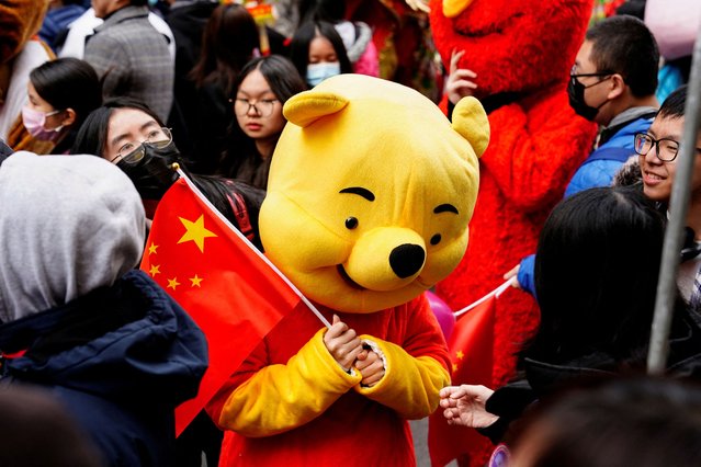 A parade participant in a Winnie the Pooh costume waves a Chinese flag before the Lunar New Year parade celebrating the Year of the Rabbit in the Chinatown neighborhood of New York, U.S., February 12, 2023. (Photo by Bing Guan/Reuters)