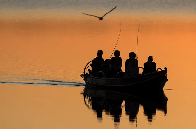 Local fishermen in a boat on the Lusiai lake near the small town of Ignalina, some 120km (74,5 miles) north of the capital Vilnius, Lithuania, Monday, June 3, 2019. (Photo by Mindaugas Kulbis/AP Photo)