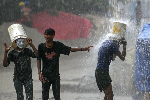 Children enjoy rain showers in New Delhi on July 9, 2024. (Photo by Arun Sankar/AFP Photo)