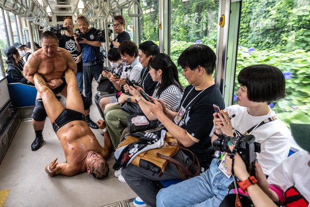 Japan's Minoru Suzuki (front) is dragged by Japan's Sanshiro Takagi during “Toden Pro Wrestling”, the first ever pro wrestling event inside a streetcar of the Toden Arakawa Line, popularly known as the Tokyo Sakura Tram, in Tokyo on June 29, 2024. (Photo by Philip Fong/AFP Photo)