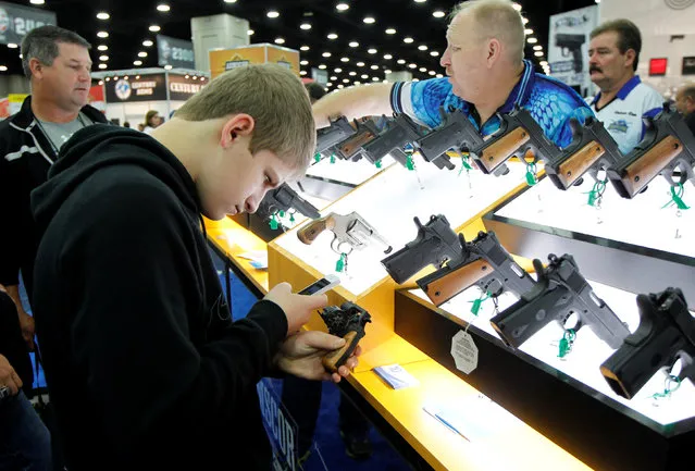 Nick Mendenhall takes a picture of a gun from Armscor USA at the National Rifle Association's annual meetings & exhibits show in Louisville, Kentucky, May 21, 2016. (Photo by John Sommers II/Reuters)