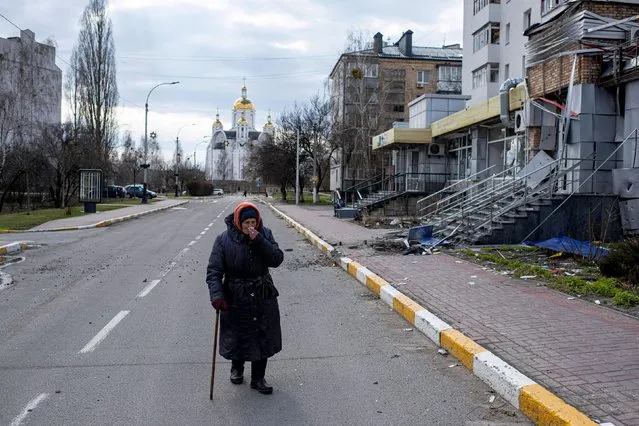 An elderly woman cries as she walks the street next to a destroyed building on April 4, 2022 in Bucha, Ukraine. The Ukrainian government has accused Russian forces of committing a “deliberate massacre” as they occupied and eventually retreated from Bucha, 25km northwest of Kyiv. Dozens of bodies have been found in the days since Ukrainian forces regained control of the town. (Photo by Alexey Furman/Getty Images)