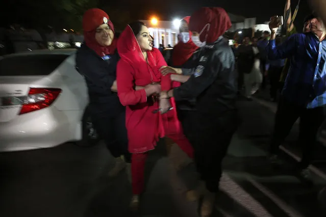 Police officers detain a supporter of Pakistan's Prime Minister Imran Khan outside the National Assembly after no-confidence vote, in Islamabad, Pakistan, Sunday, April 10, 2022. Pakistan's political opposition ousted the country's embattled prime minister in a no confidence vote on Saturday, which they won after several of Imran Khan's allies and a key coalition party deserted him. (Photo by Anjum Naveed/AP Photo)