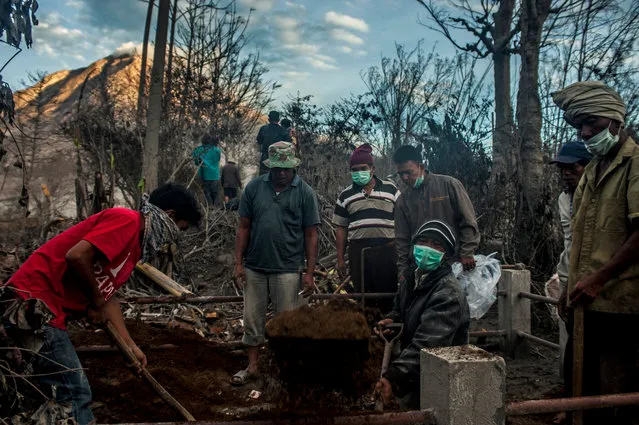 Family members dig up the tomb of an ancestor in Gamber village. (Photo by Sutanta Aditya/Barcroft Images)