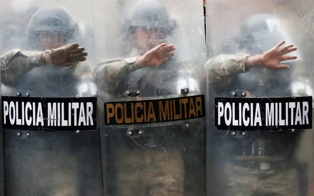 Military Police officers stand guard as supporters of former Bolivian President Evo Morales take part in a protest in La Paz, Bolivia on November 14, 2019. (Photo by Carlos Garcia Rawlins/Reuters)