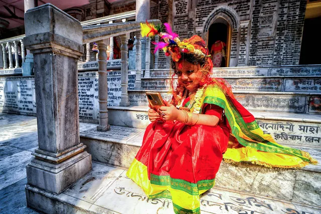 A young girl seen on her mobile after participating in the Kumari Puja at the adyapith temple in Kolkata, India on April 10, 2022. Kumari Puja is an Indian Hindu Tradition mainly celebrated during the Durga Puja / Basanti Puja / Navratri according to Hindu calendar. Kumari actually describes a young virgin girl from the age 1 to 16 who is getting worshipped during the transition of Ashtami / Navami tithi of Durga Puja / Navratri according to Hindu mythology. It is believed that Kumari Puja grants many blessings to the worshipers and as well as the little Girl too. Devotees believe it will overcome all barriers, dangers for the little girls in the coming future and also, she will be empowered to handle any stress and obstruction in her coming life. (Photo by Avishek Das/SOPA Images/LightRocket via Getty Images)