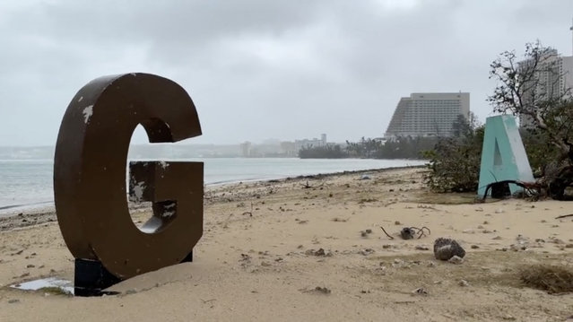 This video capture from James Reynolds' Twitter page @EarthUncutTV shows the giant letters spelling GUAM, a tourist spot on the beach, damaged by high winds and precipitation a day after Typhoon Mawar passed over Tumon Bay, Guam, May 25, 2023. Typhoon Mawar passed just north of the US territory of Guam on May 24, the island's governor said, bringing destructive winds to the Pacific military outpost. (Photo by James Reynolds/AFP Photo)