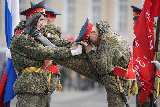 Honour guard soldiers warm up prior to a rehearsal for the Victory Day military parade which will take place at Dvortsovaya (Palace) Square on May 9 to celebrate 77 years after the victory in World War II in St. Petersburg, Russia, Tuesday, April 26, 2022. (Photo by Dmitri Lovetsky/AP Photo)