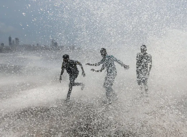 People get drenched by a large wave during high tide at a seafront in Mumbai, India, June 12, 2017. (Photo by Danish Siddiqui/Reuters)