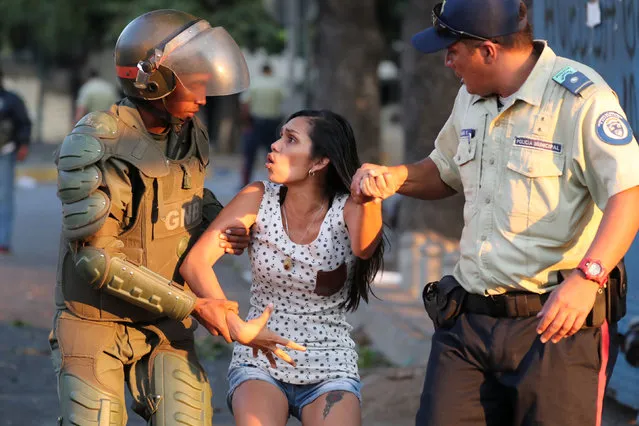 A woman is detained by security forces after looting broke out during an ongoing blackout in Caracas, Venezuela, March 10, 2019. (Photo by Ivan Alvarado/Reuters)
