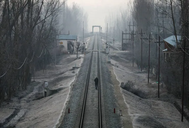 A man walks on a frost-covered railway track on a cold winter morning on the outskirts of Srinagar, December 27, 2019. (Photo by Danish Ismail/Reuters)