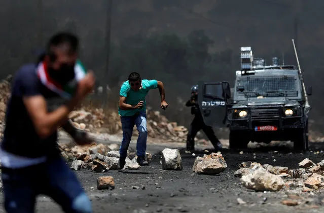 Palestinian protesters run for cover during clashes with Israeli troops following a protest against the nearby Jewish settlement of Qadomem, in the West Bank village of Kofr Qadom, near Nablus July 7, 2017. (Photo by Mohamad Torokman/Reuters)