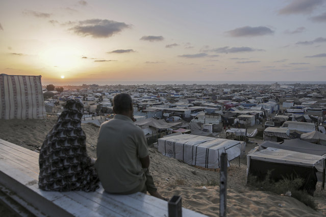 Palestinians displaced by the Israeli air and ground offensive on the Gaza Strip sit at a makeshift tent camp in Khan Younis, Gaza, Tuesday, June 18, 2024. (Photo by Jehad Alshrafi/AP Photo)