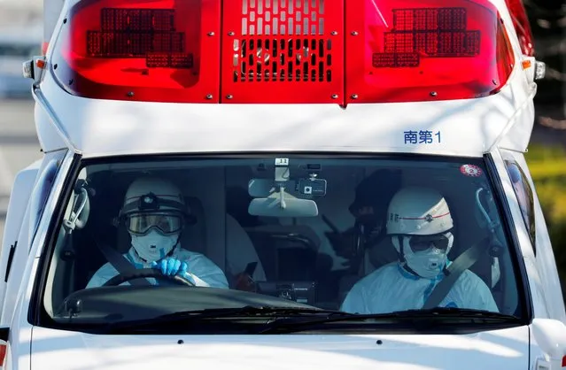 Workers in protective gears drive an ambulance which is believed to be carrying a person transferred from cruise ship Diamond Princess at a maritime police's base in Yokohama, Japan on February 5, 2020. Around 3,700 people are facing at least two weeks locked away on a cruise liner anchored off Japan after health officials confirmed that 10 people on the ship had tested positive for coronavirus and more cases were possible. (Photo by Kim Kyung-Hoon/Reuters)