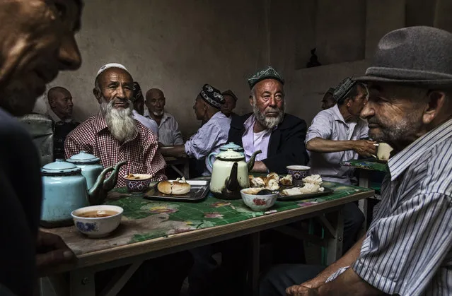 Ethnic Uyghur men talk as they meet at a teahouse on July 1, 2017 in the old town of Kashgar, in the far western Xinjiang province, China. (Photo by Kevin Frayer/Getty Images)