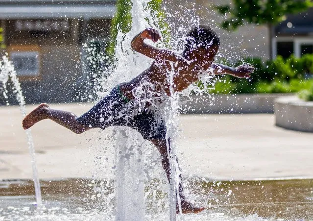 Damian Stewart, 8, plays in the splash pad at Howard Park, Tuesday, June 14, 2022, in downtown South Bend, Ind. (Photo by Michael Caterina/AP Photo)