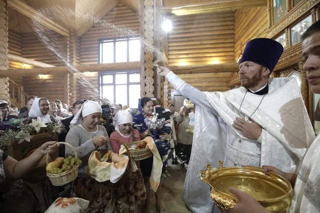 A Russian Orthodox priest blesses fruits with holy water during the celebrations of the Orthodox holiday Yablochny Spas, or “Apple Salvation”, in a church in Moscow, Russia, 19 August 2015. (Photo by Maxim Shipenkov/EPA)