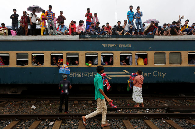 People sit atop of an overcrowded passenger train as they travel home to celebrate Eid al-Fitr festival, which marks the end of the Muslim holy fasting month of Ramadan, at a railway station in Dhaka, Bangladesh, July 5, 2016. (Photo by Adnan Abidi/Reuters)