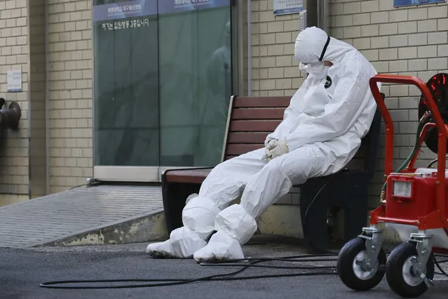 A member of the medical team takes a rest outside a hospital in Daegu, South Korea, Sunday, February 23, 2020. South Korea's president has put his country on its highest alert for infectious diseases, saying Sunday that officials should take “unprecedented, powerful” steps to fight a viral outbreak. (Photo by Im Hwa-young/Yonhap via AP Photo)