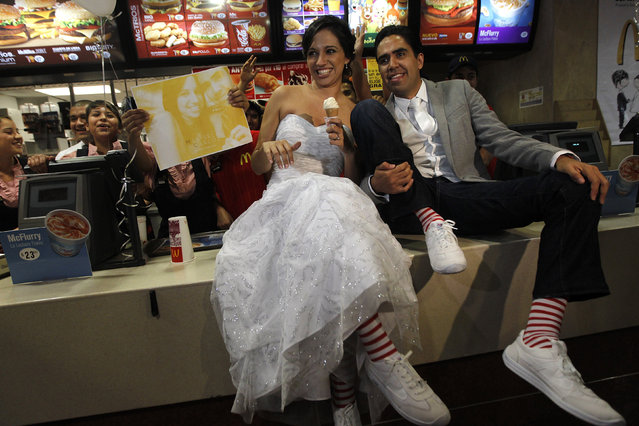 Fast-food fanatics Marisela Matienzo and Carlos Munoz pose for a picture after getting married at a McDonald's in the suburb of San Pedro Garza, neighbouring Monterrey November 26, 2010. The local franchise for McDonald's Corp said the wedding was the first in one of its outlets in Latin America. (Photo by Tomas Bravo/Reuters)
