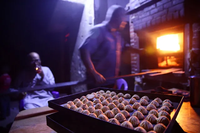 Men prepare traditional sweets ahead of the Eid al-Fitr holiday marking the end of Ramadan in the rebel held besieged town of Douma, eastern Ghouta in Damascus, Syria, July 3, 2016. (Photo by Bassam Khabieh/Reuters)