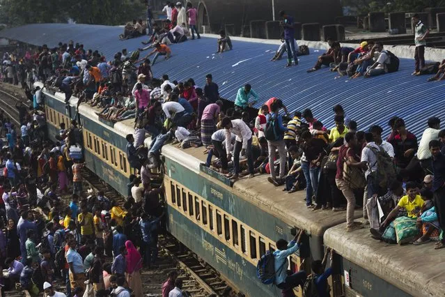 Bangladeshi Muslims climb onto the roof of an overcrowded train to travel to their hometowns ahead of of Eid al-Adha in Dhaka, Bangladesh, Friday, September 1, 2017. (Photo by Bernat Armangue/AP Photo)