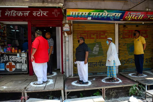 People stand on designated areas to maintain social distancing as they queue outside a medical store during the first day of a 21-day government-imposed nationwide lockdown as a preventive measure against the COVID-19 coronavirus in Allahabad on March 25, 2020. (Photo by Sanjay Kanojia/AFP Photo)
