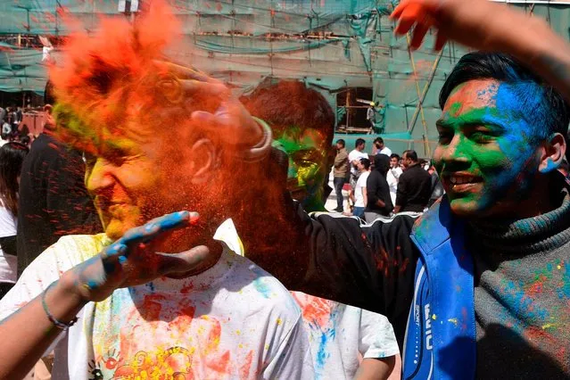 Revellers play with coloured powders as they celebrate Holi, the spring festival of colours, in Kathmandu on March 9, 2020. Holi is observed at the end of the winter season on the last full moon of the lunar month. (Photo by Prakash Mathema/AFP Photo)