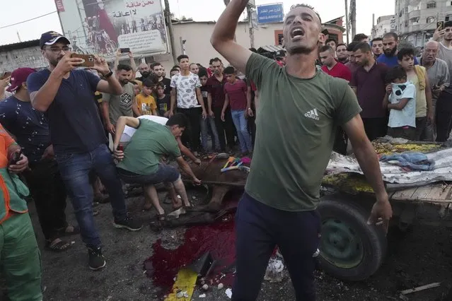 A youth reacts while other residents inspect a wounded horse near a damaged car that was hit in an Israeli airstrike that killed people in the car and the horse cart, at the main road in Gaza City, Sunday, August 7, 2022. (Photo by Adel Hana/AP Photo)