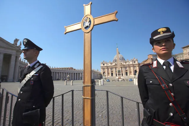 Italian Carabinieri stand by a cross, donated to them during the Holy Year of 2016, placed by an empty St. Peter's Square in homage to Pope Francis while the pope celebrated an Easter Mass inside an empty St. Peter's Basilica, at the Vatican, Sunday, April 12, 2020. Pope Francis and Christians around the world marked a solitary Easter Sunday, forced to celebrate the most joyful day in the liturgical calendar amid the sorrowful reminders of the devastation wrought by the coronavirus pandemic. (Photo by Andrew Medichini/AP Photo)