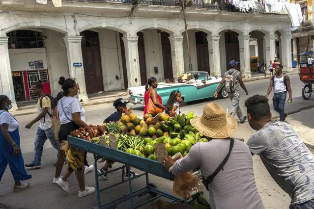 Street vendors push their cart filled with produce in Havana, Cuba, Thursday, August 4, 2022. Cuba's socialist government last year approved a package of 63 reforms meant to make it easier and more profitable for producers to get food to consumers. (Photo by Ramon Espinosa/AP Photo)