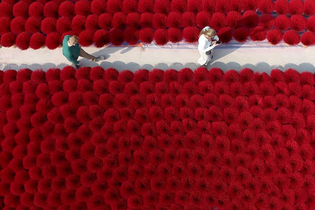 This aerial picture shows tourists walking next to bundles of incense sticks in Quang Phu Cau village on the outskirts of Hanoi on January 21, 2025, ahead of Lunar New Year celebrations, known in Vietnam as Tet. (Photo by Nhac Nguyen/AFP Photo)