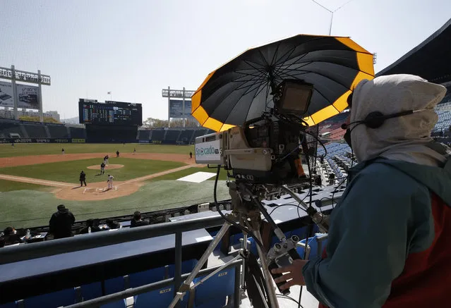 A TV cameraman films the LG Twins baseball team's intrasquad game in Seoul, South Korea, Sunday, April 5, 2020. The intrasquad game is aired live through the team's YouTube channel for its fans. The Korea Baseball Organization has postponed the start of new season to prevent the spread of the new coronavirus. (Photo by Lee Jin-man/AP Photo)