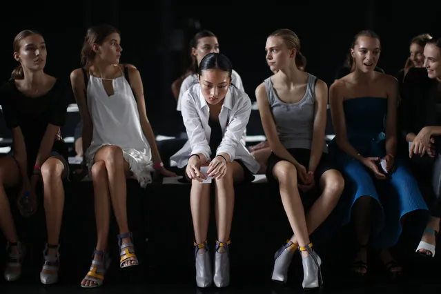 Jing Wen, center, of Guangzhou, China, waits to rehearse with other models before the Prabal Gurung Spring 2015 collection show Saturday, September 6, 2014, during Fashion Week in New York. Jing Wen, 19, began modeling at age 17. She says that as a little girl, she loved the idea of modeling, but never dreamed that she would end up walking runways internationally. Although her mother and sister are back in China, she doesn't often suffer from homesickness. (Photo by Jason DeCrow/AP Photo)