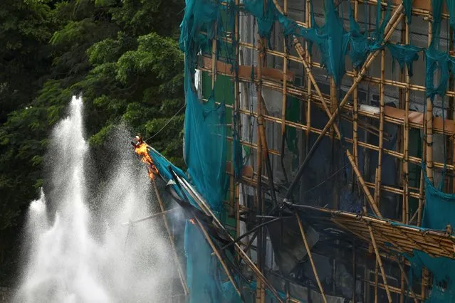 Water jets ejected from Fire Engines extinguished the bamboo scaffoldings suddenly caught fire at the construction sit in Hong Kong on September 21, 2022. (Photo by Liau Chung-ren/ZUMA Press Wire/Rex Features/Shutterstock)