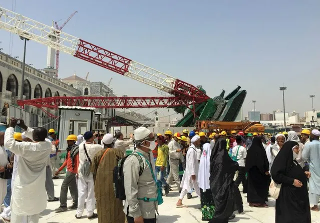 Muslim pilgrims walk near a construction crane which crashed in the Grand Mosque in the Muslim holy city of Mecca, Saudi Arabia September 12, 2015. (Photo by Mohamed Al Hwaity/Reuters)