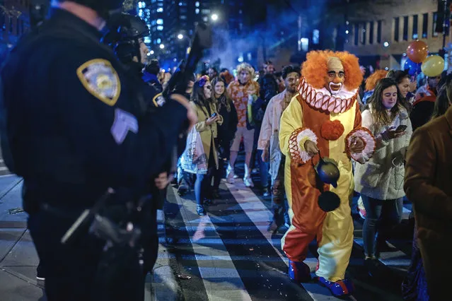 Heavily armed police guard as revelers march during the Greenwich Village Halloween Parade, Tuesday, October 31, 2017, in New York. (Photo by Andres Kudacki/AP Photo)