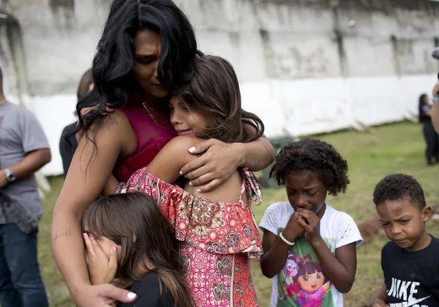 Female inmate Rossana Goncalves with four of her five children cry as they reunite on the sidelines of competing in her jail's annual beauty contest at Talavera Bruce penitentiary in Rio de Janeiro, Brazil, early Thursday, November 23, 2017. The event aims to improve the women’s self-esteem and is an opportunity to unite with family members they seldom see. (Photo by Silvia Izquierdo/AP Photo)