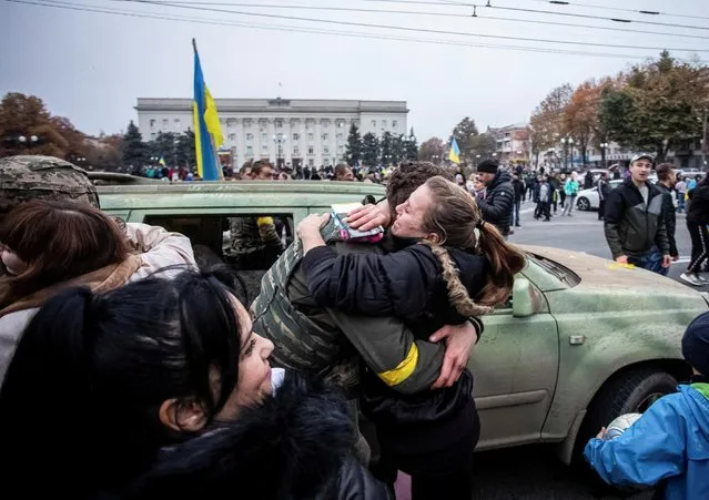 A local resident hugs Ukrainian serviceman as people celebrate after Russia's retreat from Kherson, in central Kherson, Ukraine on November 12, 2022. (Photo by Yevhenii Zavhorodnii/Reuters)