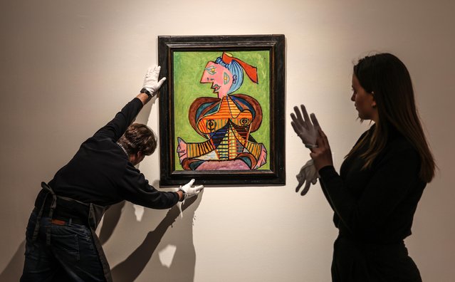 Art handlers at Christie’s in London early March 2025 adjust Pablo Picasso’s Femme à la coiffe d’Arlésienne sur fond vert (1937), part of the Leonard and Louise Riggio collection, which will be auctioned in New York in May. (Photo by Richard Pohle/The Times)